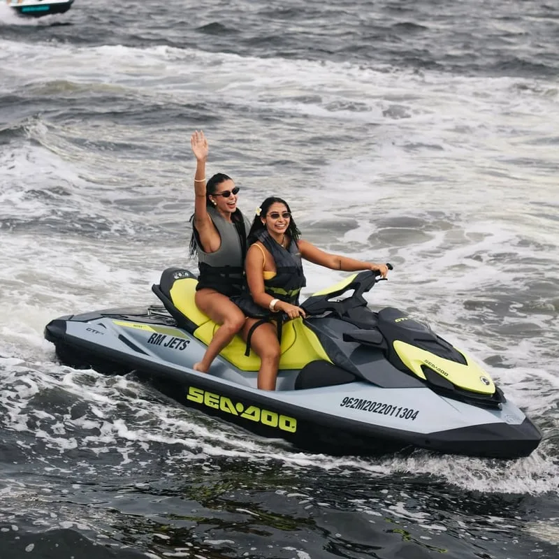 Duas pessoas em Jet Ski amarelo navegando na água