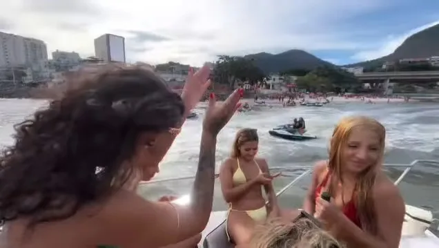 Pessoas celebrando em ambiente à beira da água, still de vídeo